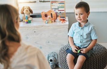 Kind sitzend in Spielzimmer
