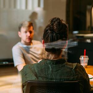 Person auf einem Stuhl sitzt Mann gegenüber